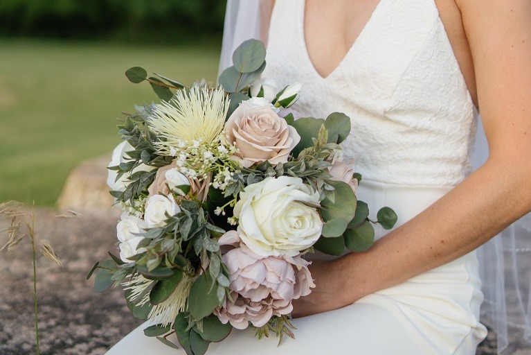 bride holding bouquet of silk stem flowers